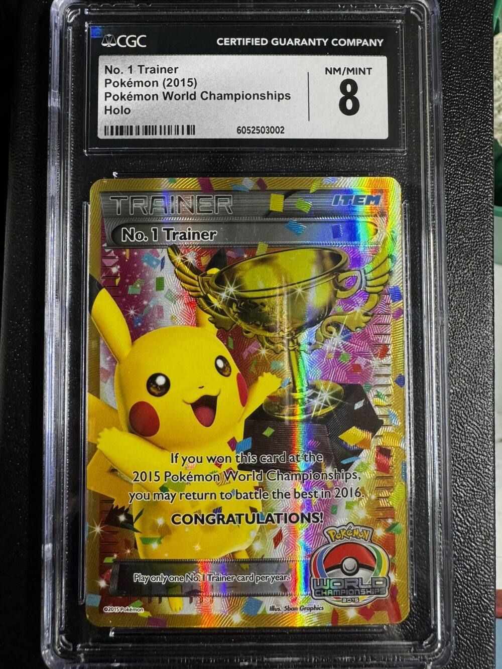 CGC-slabbed No. 1 Trainer trophy card from the 2015 Pokémon World Championships, Pikachu beside a gold trophy, graded 8, from the eBay listing
